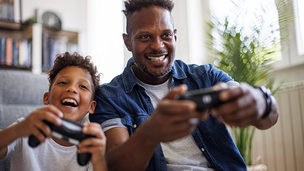 père et fils jouant à un jeu vidéo sur console